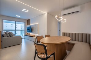 A modern living room with a sofa, a round wooden dining table, and a built-in bench. - Apt in a Building w/ Gym 200m From the Sea Ptc1105 (Picarras)