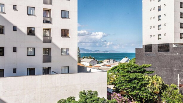 Un edificio de varios pisos con balcones y vista al mar.