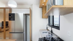 Una cocina moderna con horno empotrado, estufa a gas y ventana con vista al agua.
