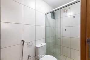 A bathroom with white tiles, a glass shower enclosure, a toilet, and a hand dryer. - Apt in Cond. w/ Pool, 700 m fr/ the Beach Mbr0204 (Maceió)