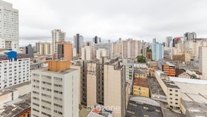 Paisagem urbana com edifícios altos, incluindo um hotel de destaque com design moderno e vários andares.
