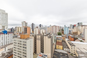 A cityscape with high-rise buildings, including a prominent hotel with a modern design and multiple floors. - Studio in Build. w/ gym in the City Center Emw1520 (Curitiba)
