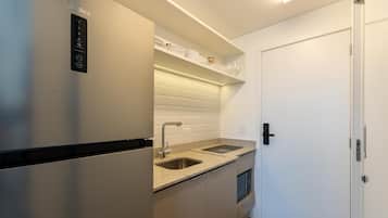 Een praktische keuken met een RVS-koelkast, een dubbele spoelbak en een magnetron.