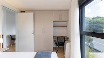 Une chambre à coucher moderne avec un lit, un bureau et une armoire.