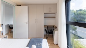 Ein modernes Schlafzimmer mit Bett, Schreibtisch und Kleiderschrank.