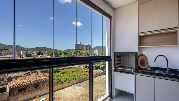 A modern kitchen with a large window, a sink, and a wooden cutting board. - Apt 650m fr/ Beto Carrero in Cond w/ Pool Lav0401 (Penha)