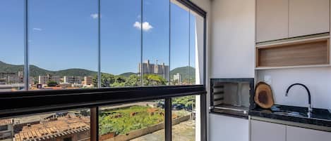 Una cocina moderna con un amplio ventanal, un lavabo y una tabla de cortar de madera.