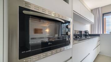 Cozinha moderna com forno embutido e máquina de café.