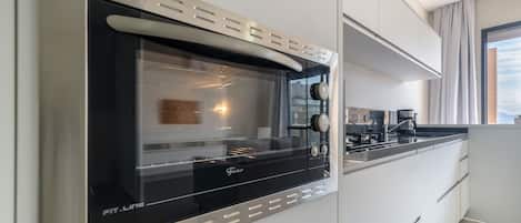 A modern kitchen with a built-in oven and a coffee machine.