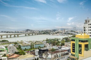 A cityscape with a river, a bridge, and modern buildings. - Studio With sea View in Downtown Floripa Tvt904 (Florianópolis)