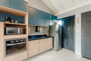 Eine moderne Küche mit integrierten Geräten, Holzschränken und einem schwarzen Kühlschrank.