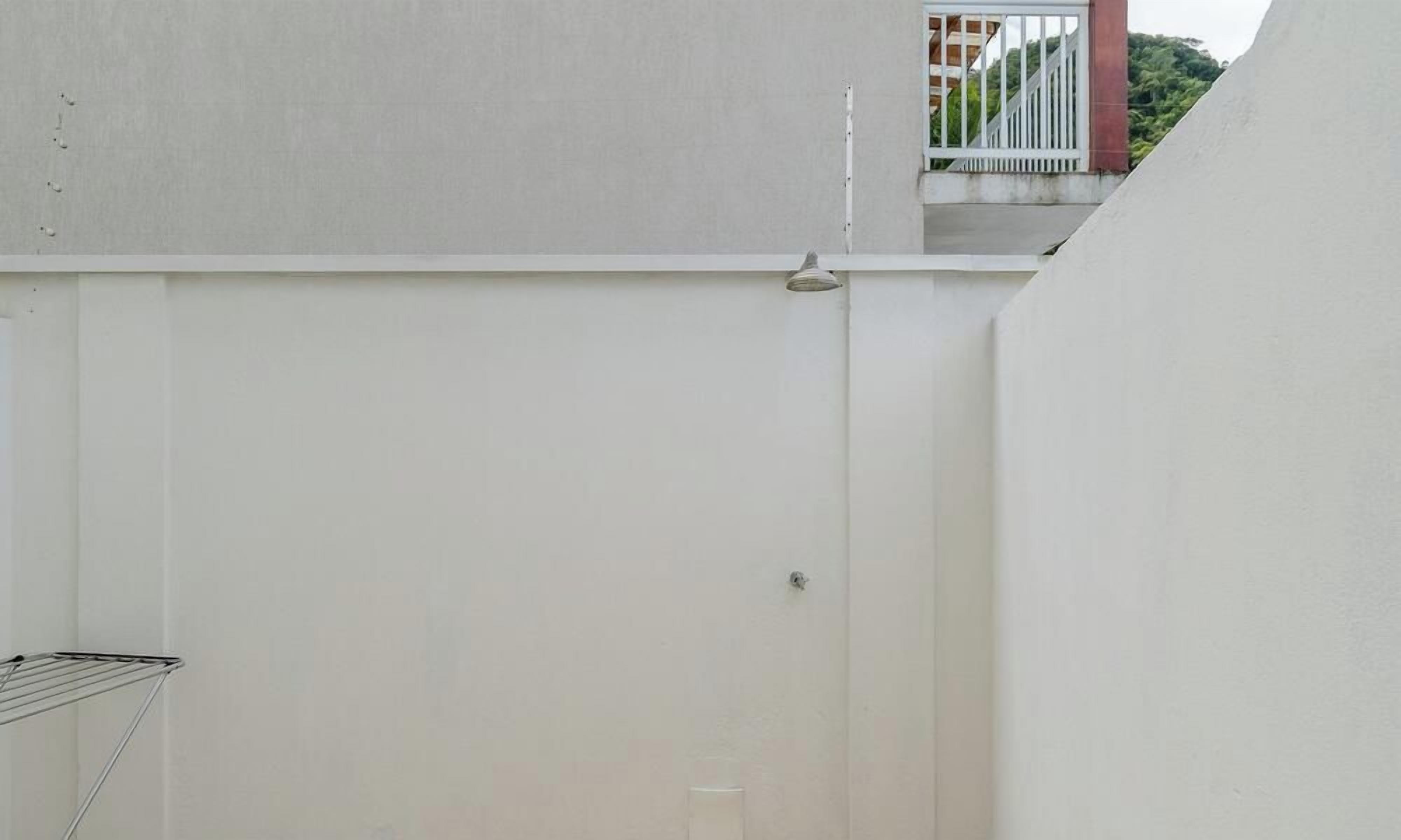 A white wall with a door and a metal rack.