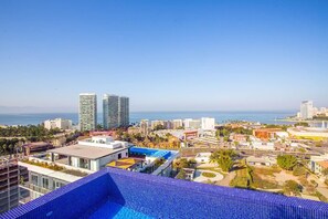 A high-rise building with a pool and a view of the sea. - Soho Skies 204 Stunning Sunset - Ocean Views wit (Puerto Vallarta)