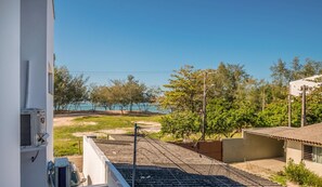 Un quartier résidentiel offrant une vue sur une plage, une voie ferrée et un immeuble équipé d’un climatiseur.