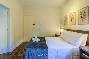 A hotel room with a bed, a nightstand, and a door. - Studio in the Historic Center of PoA Els0902 (Porto Alegre)