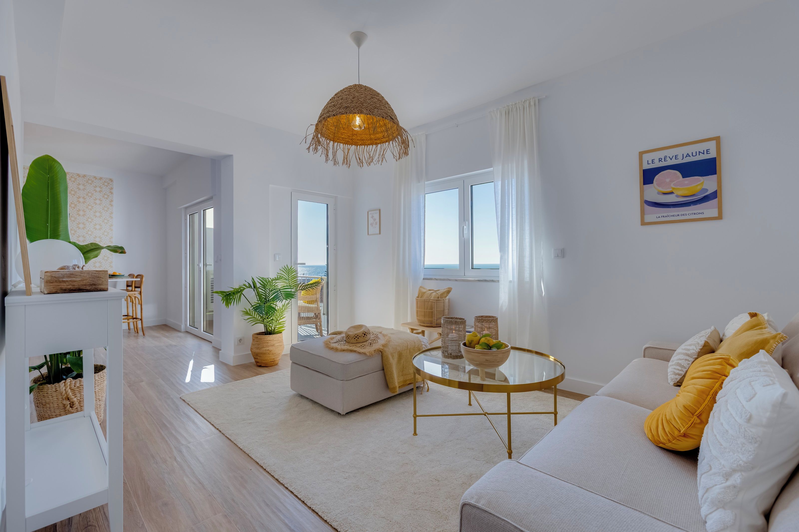 A modern living room with a sofa, a round coffee table, and a hanging light fixture.