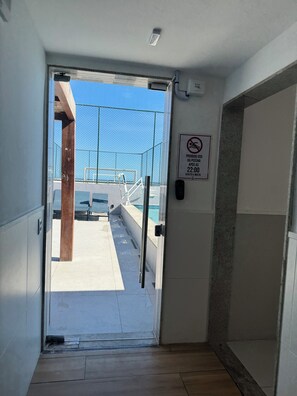 Porta de entrada para área de piscina com aviso de proibição de nadar.