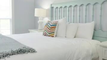 Une chambre d’hôtel avec un lit, une table de chevet, une lampe et une fenêtre.