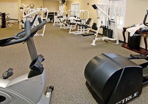 Ein Fitnessstudio mit Trainingsgeräten, darunter Laufbänder und Kraftgeräte.