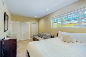 A bedroom with a bed, a desk, a chair, a window, and a door. - Go with the Flow - Pet Friendly (Hollywood)