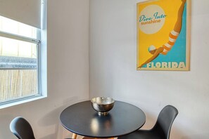 Ein Zimmer mit einem runden Tisch, einer Schale auf dem Tisch und einem Poster an der Wand.