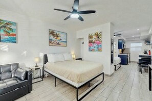 A modern bedroom with a bed, a sofa, a desk, and a kitchenette. - Sunshine, Beach & Smiles on Ocean Drive (Miami Beach)