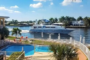 A large yacht docked near a swimming pool with a view of the water and palm trees. - Aloha Beach Holiday - Waterfront (Pompano Beach)