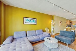 A modern living room with a sectional sofa, a smaller sofa, and a coffee table. - The Ocean Reserve 1607 (Sunny Isles Beach)