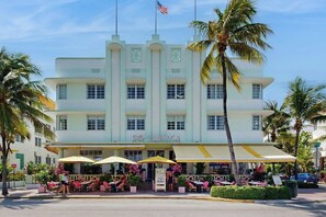 A multi-story hotel with a classic architectural style, featuring a prominent entrance with outdoor seating and palm trees. - The Carlyle 3G - Near Beach (Miami Beach)
