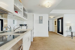 A modern kitchen with a double sink, stainless steel appliances, and a built-in microwave. - The Carlyle 3G - Near Beach (Miami Beach)