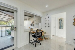 A modern interior with a desk, chair, and artwork on the walls. - 2 BR Home with Private Patio & Grill (Wilton Manors)