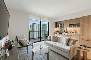 A modern apartment with a living area, kitchenette, and a large window with a city view. - The Grand Vista 4501 (Miami)