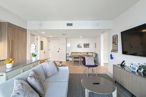 A modern living room with a sofa, coffee table, and a TV mounted on the wall. - The Grand Vista 4501 (Miami)