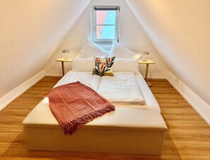 A small, cozy bedroom with a single bed, a window, and two bedside lamps. - A Hidden Gem in the Heart of Ingolstadt (Ingolstadt)