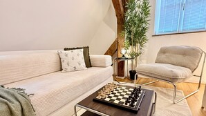 A modern living room with a sofa, a chair, a chessboard, and a potted plant. - A Hidden Gem in the Heart of Ingolstadt (Ingolstadt)