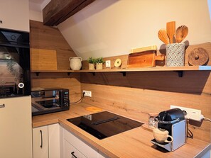 A modern kitchen with a built-in oven, a coffee machine, and wooden shelves with kitchen utensils. - A Hidden Gem in the Heart of Ingolstadt (Ingolstadt)