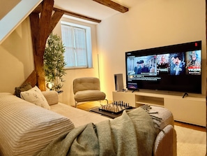 Mukava huone, jossa on sänky, tuoli, televisio ja shakkilauta.