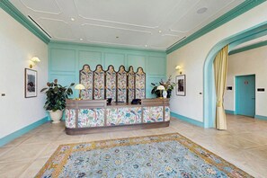 A reception area with a patterned console table, a large decorative mirror, and a floral rug. - NoMad #715 - Private Balcony (Miami)