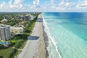 Ein Hotel an der Küste mit Blick auf den Strand, mehreren Gebäuden und blauem Himmel.