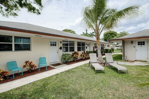 Ein Motel mit überdachtem Gang, Außenbereich und einer Palme.