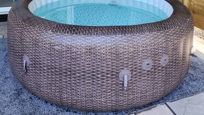 A hot tub with a wicker exterior, a glass door, and a wooden ceiling. - The Pigsty at the Secret Garden (Ashford)