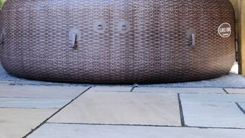 Ein großes, strukturiertes braunes Objekt auf einer gefliesten Terrasse.