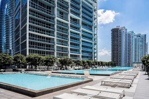 A modern hotel with a rooftop pool area, multiple swimming pools, and high-rise buildings in the background. - Tony Ultimate Experience Miami (Miami)