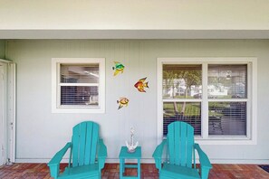 A porch with two turquoise chairs, a small table with a decorative item, and three fish wall decals. - Pompano Beach Getaway (Pompano Beach)