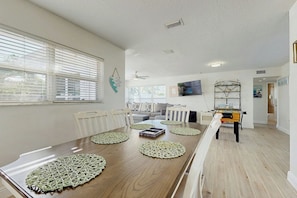A spacious living area with a wooden dining table, white chairs, and a sofa. - Pompano Beach Getaway (Pompano Beach)