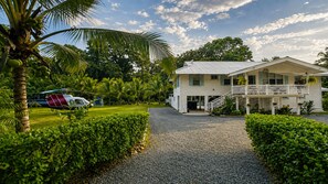Ein Haus mit Veranda, einem Schotterweg und einem abgestellten Flugzeug.