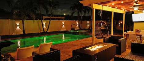An outdoor pool area with a fire pit and seating.
