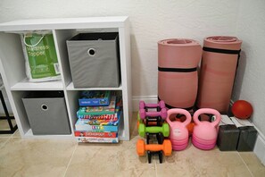 A storage unit with a mattress topper and exercise equipment including dumbbells and kettlebells. - Terrace 17 - Private Pool (Fort Lauderdale)