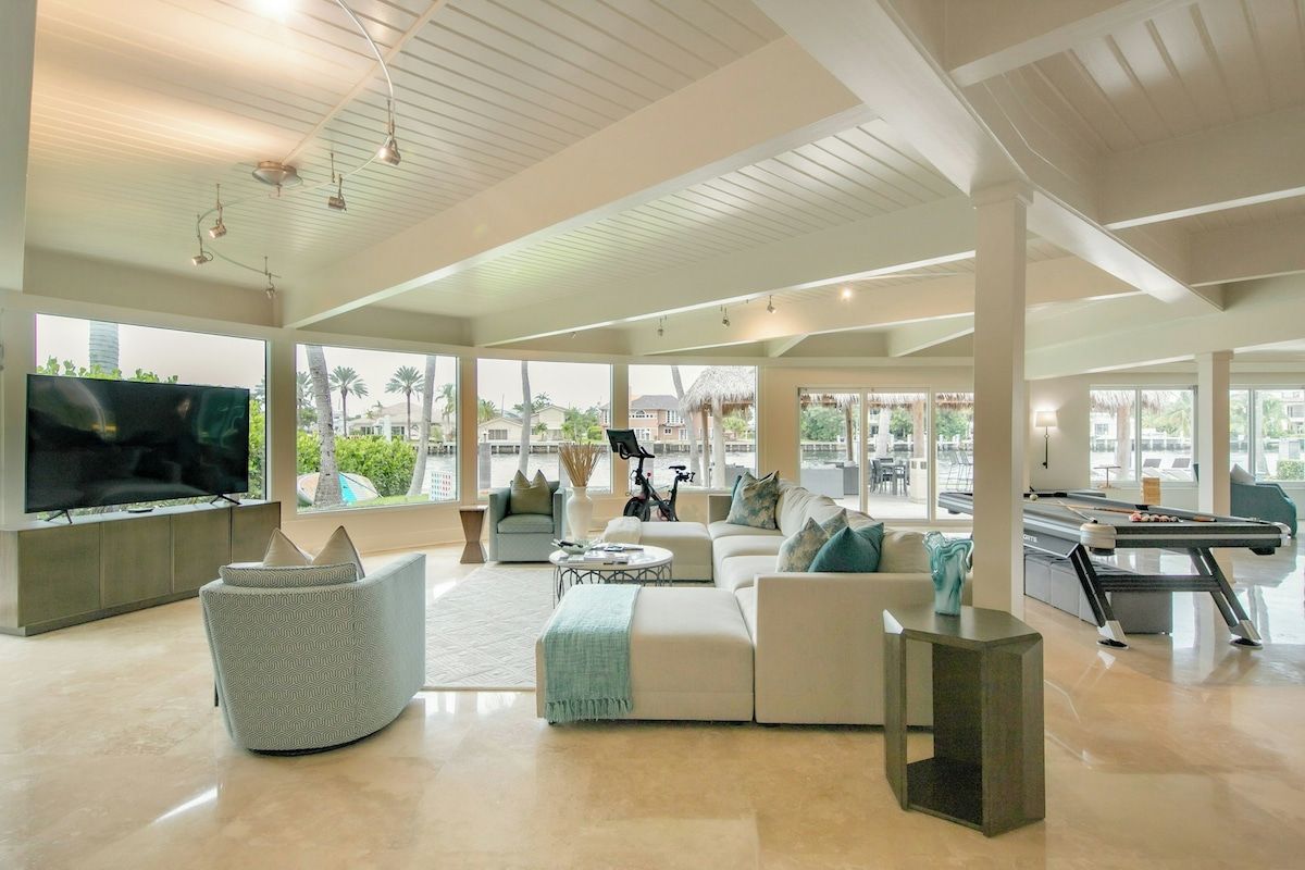 A spacious living area with a pool table, comfortable seating, and a television.