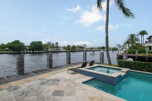 A pool area with a view of a water body and buildings in the background. - Paradise Manor - Private Pool (Pompano Beach)